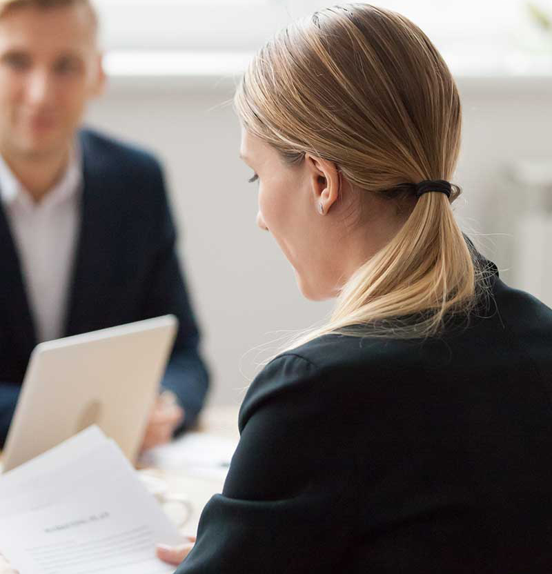 Focused serious businesswoman reading document at group meeting